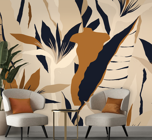 Two gray chairs with orange cushions in front of a wall with abstract leaf pattern