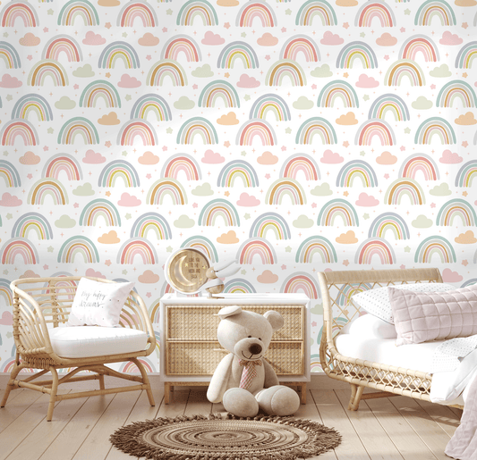 Nursery room with rainbow and cloud patterned wallpaper, wicker furniture, and a teddy bear.