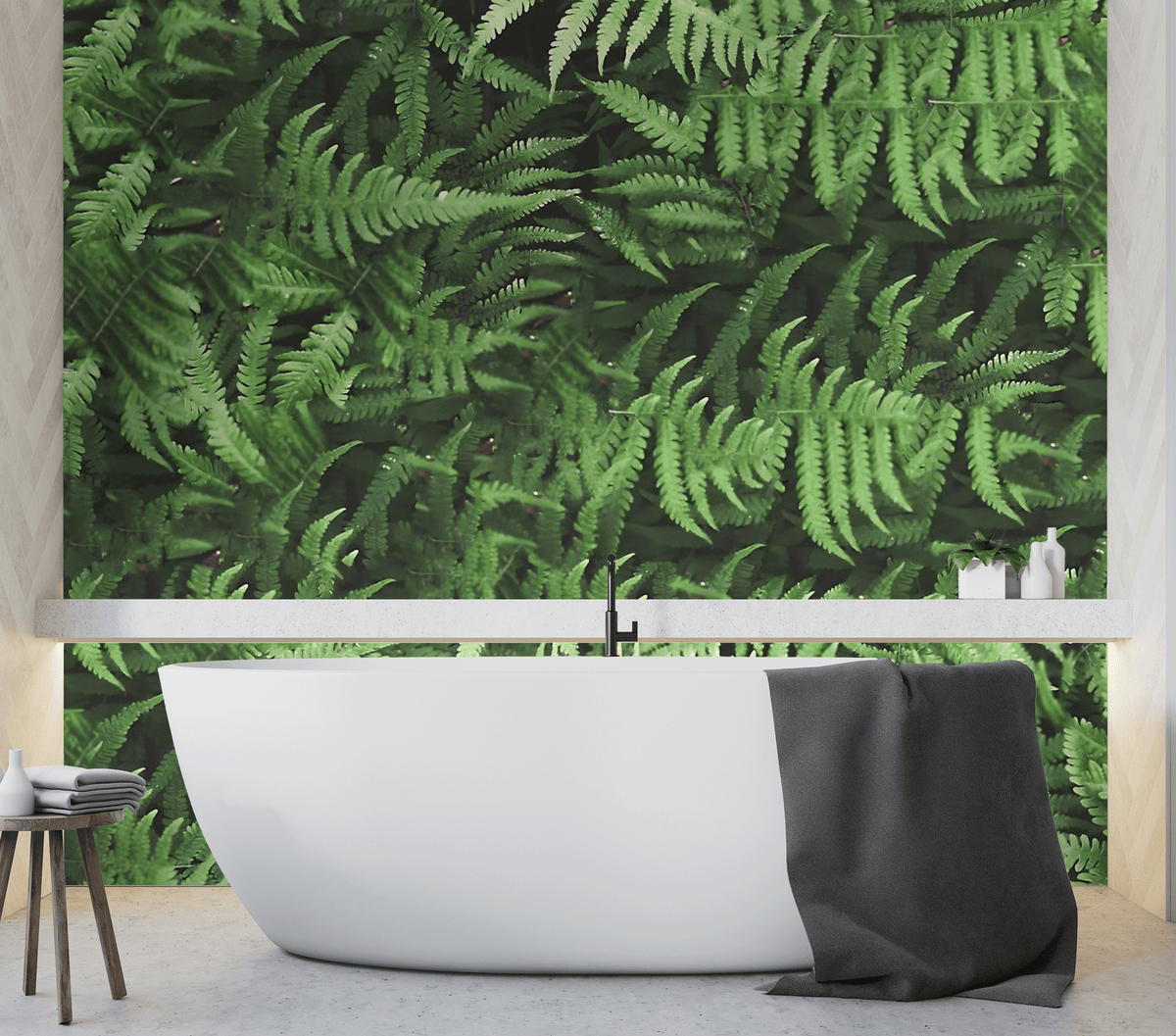Modern bathroom with a white freestanding bathtub against a green fern wall.