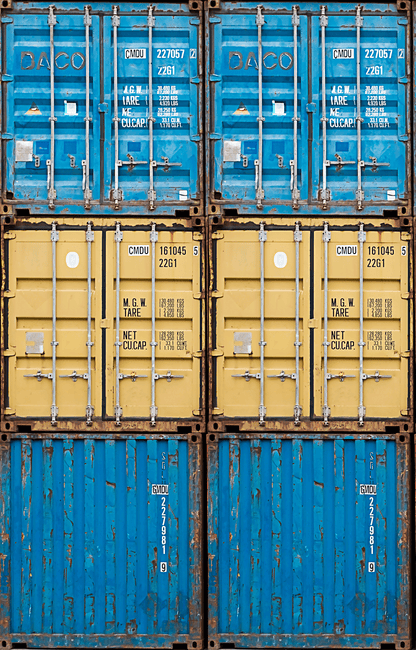 Stack of blue and yellow shipping containers with visible labels.